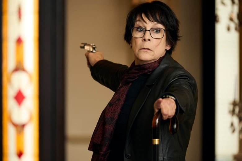 A woman holds a gun.