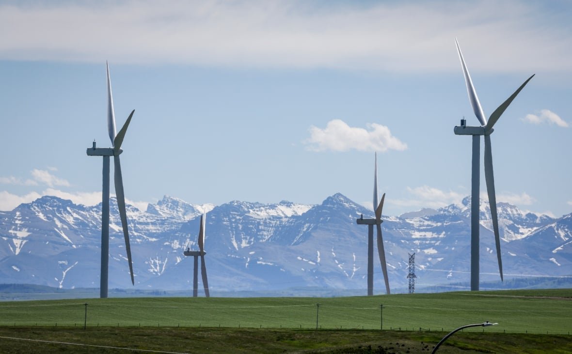 Wind turbines are seen with the Rocky Mountains in the background near Pincher Creek, Alta. The new emissions targets help drive business certainty and investment into clean technologies, experts say.