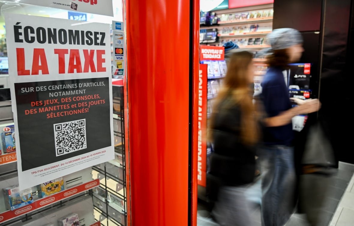 People walk out of a store displaying a sign that reads, 'Save the tax,' written in French.