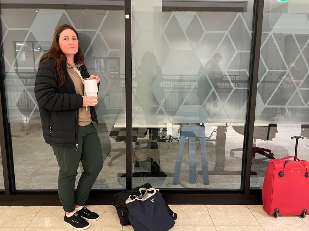 A woman stands in line, waiting to hopefully get a desk to work at inside a shopping centre. 