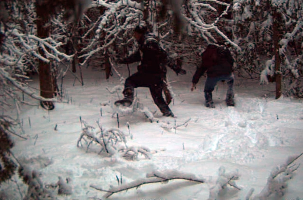 two people trudging through the snow.