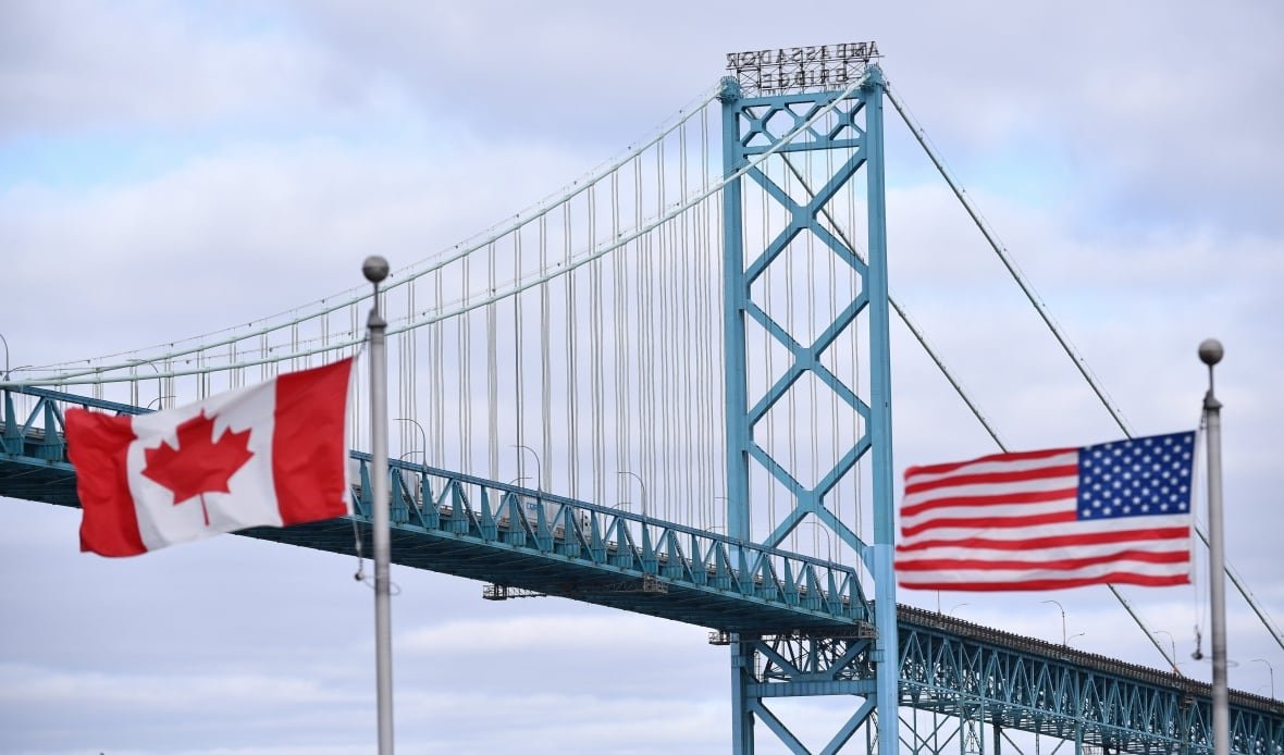 Canadian and American flags fly near the Windsor-Detroit Ambassador Bridge