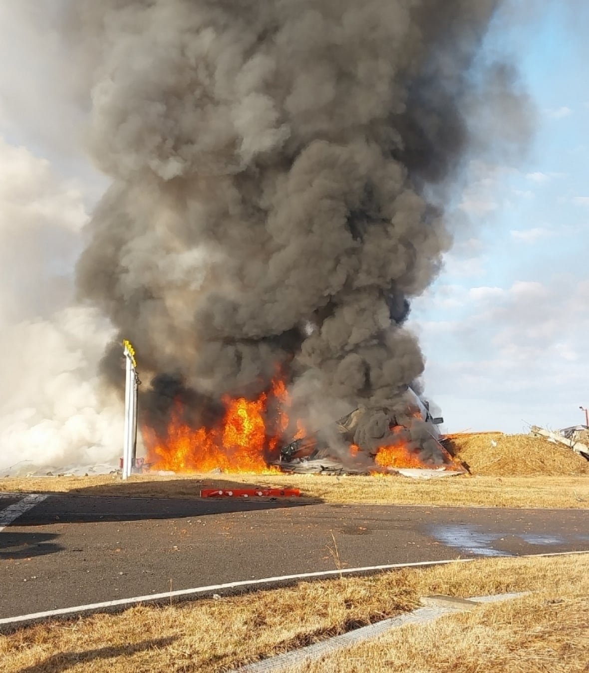 Smoke and fire rises from the wreckage of a downed airplane.