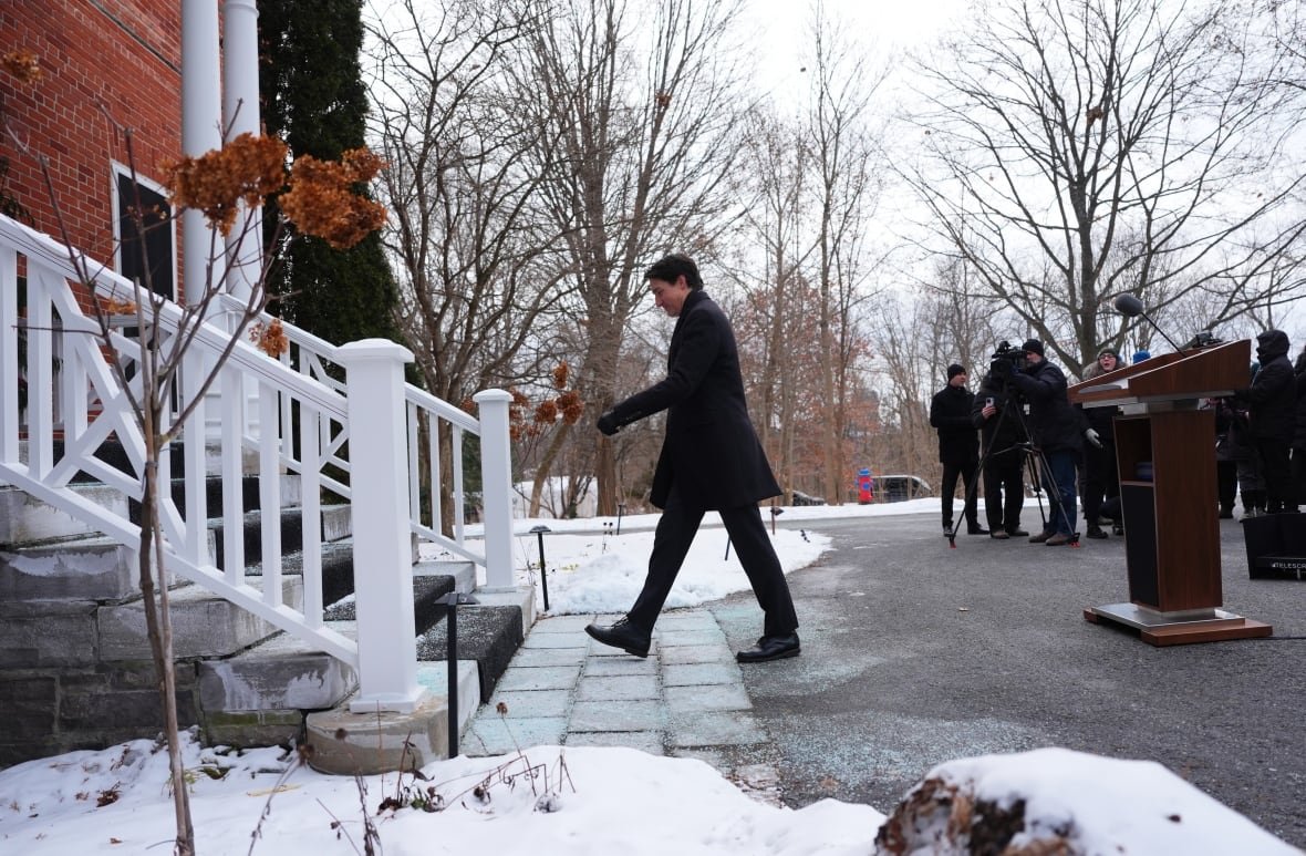 A man walks toward stairs outdoors.