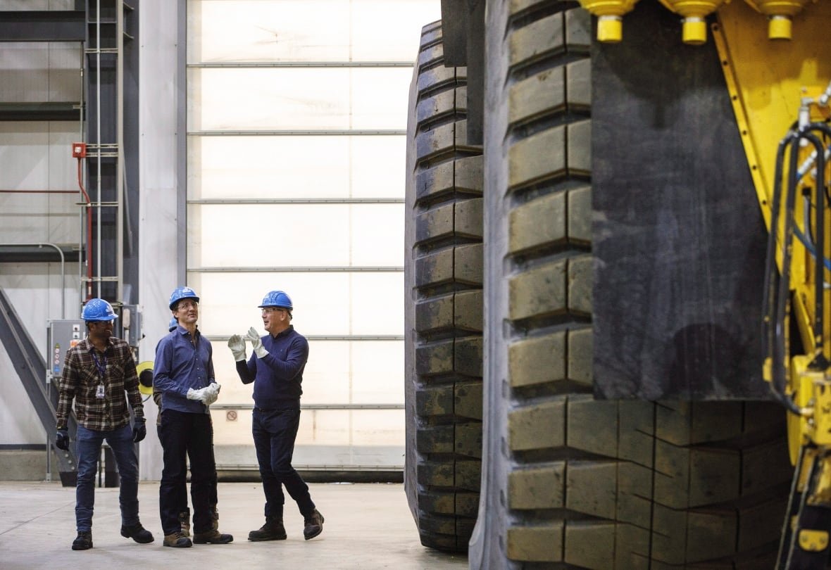 Prime Minister Justin Trudeau and Suncor CEO Steve Williams, right tour a Komatsu 980E truck at Suncor's Fort Hills facility near Fort McMurray, Alta., on Friday, April 6, 2018.