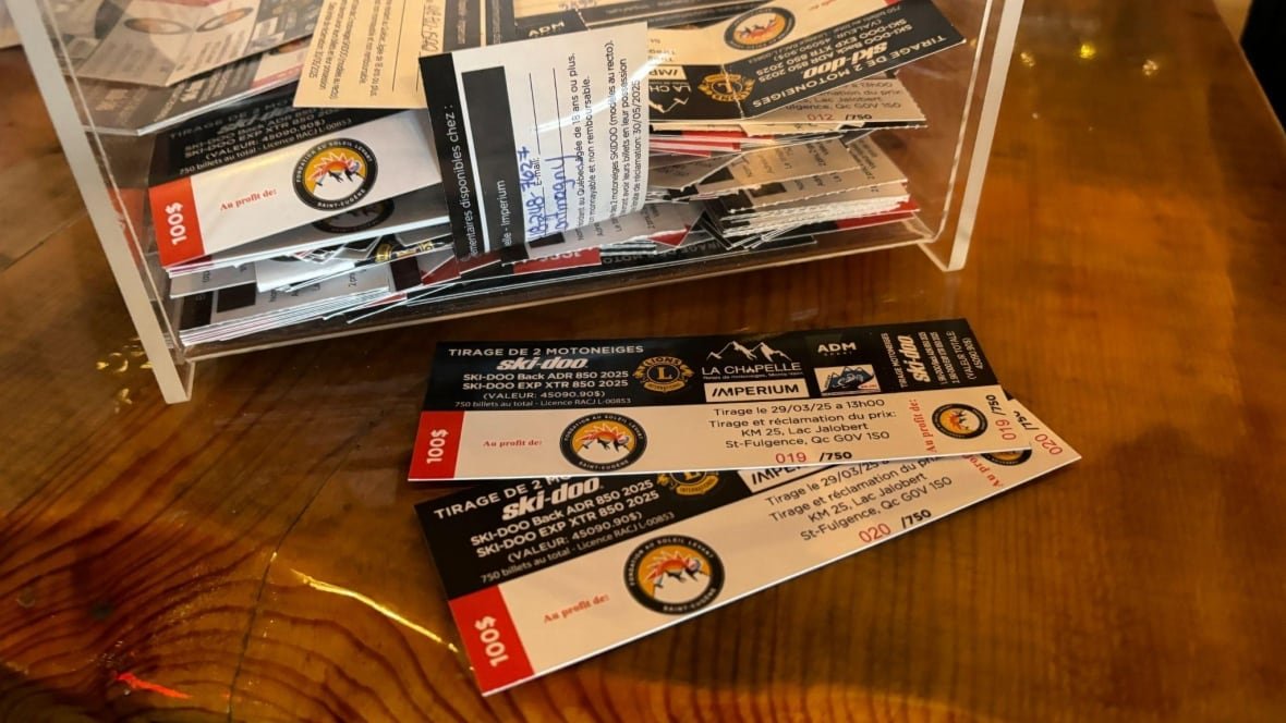 Raffle tickets are placed in a container and spread out on a counter.