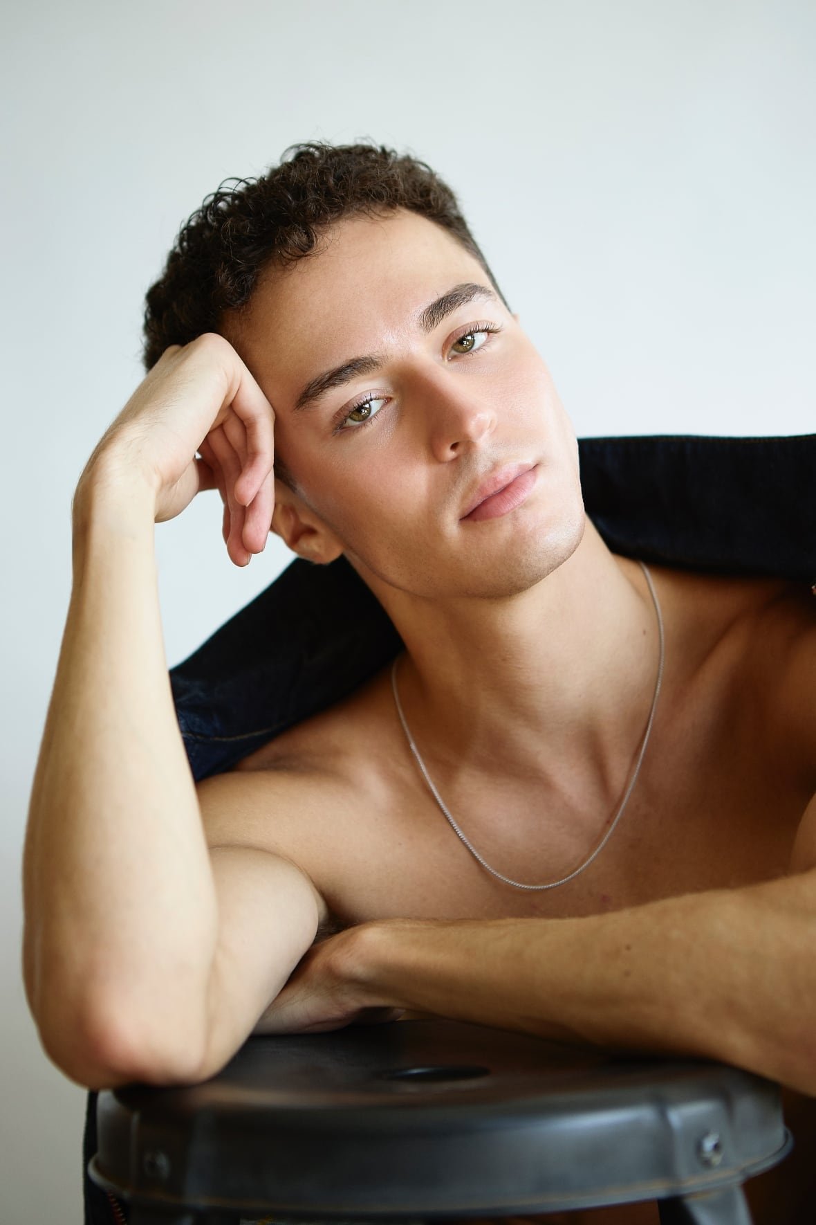 A shirtless male model poses.