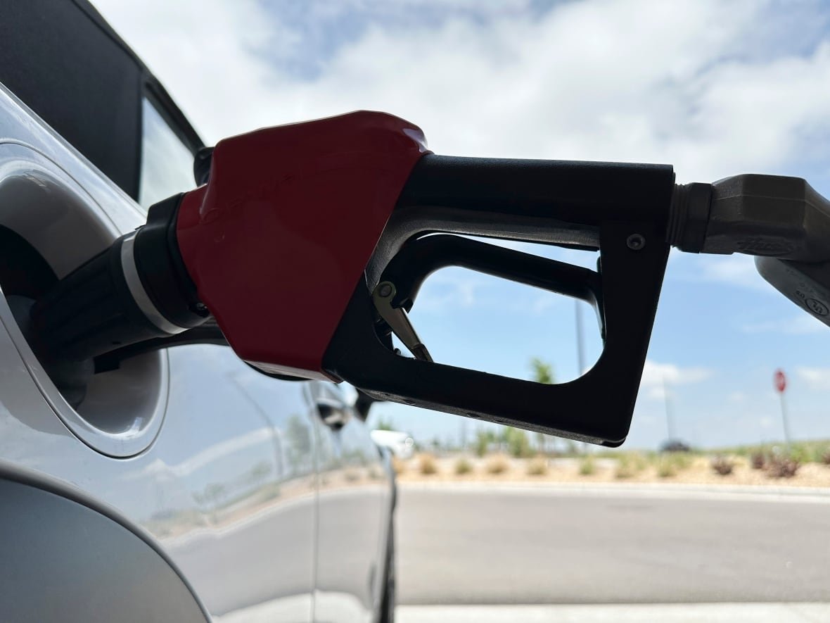 A close up of a gasoline nozzle in a vehicle's gas tank.