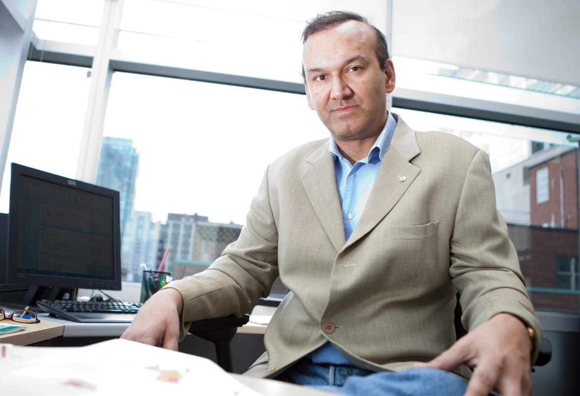 A man sitting in his office looks at a camera