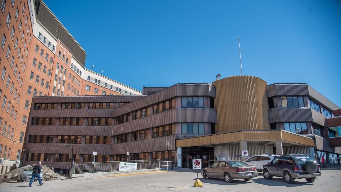 A brown hospital building seen on a day with a clear blue sky.