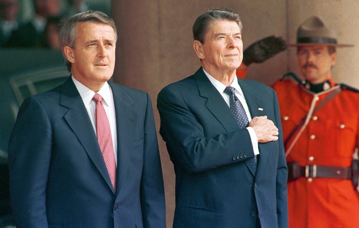 Brian Mulroney, Ronald Reagan, and a Mountie are seen standing alongside one another, at a G7 summit in Toronto in 1988.