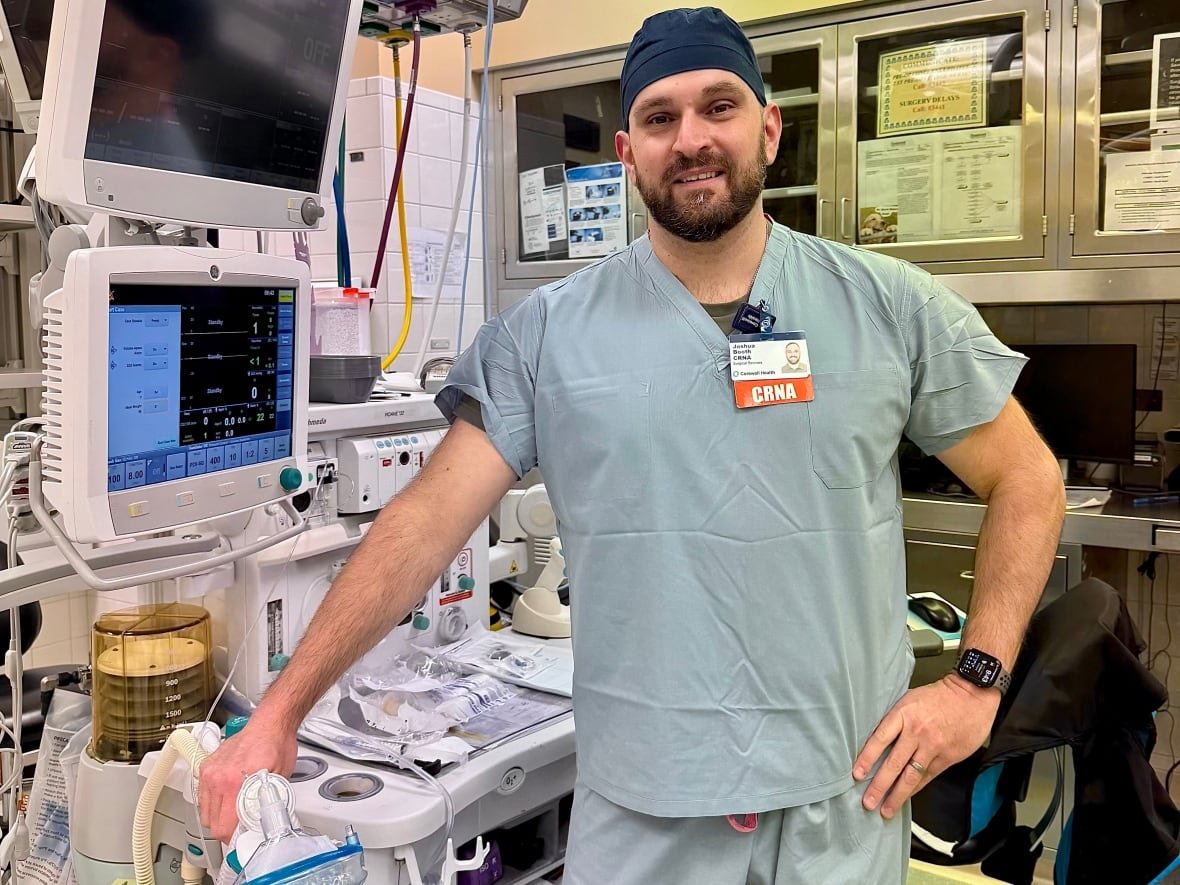 A nurse stands in front of specialized anesthesia equipment.