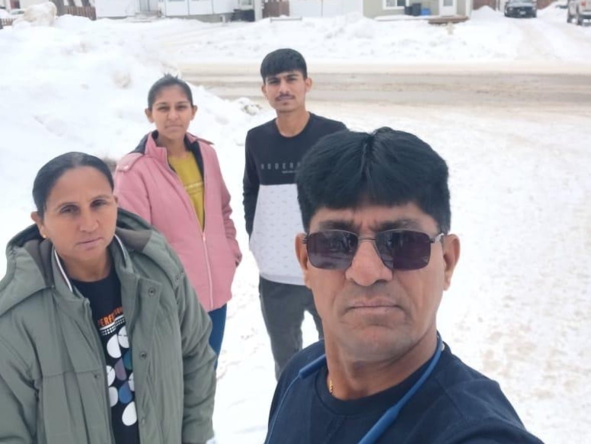 A family of four take a selfie in the snow.