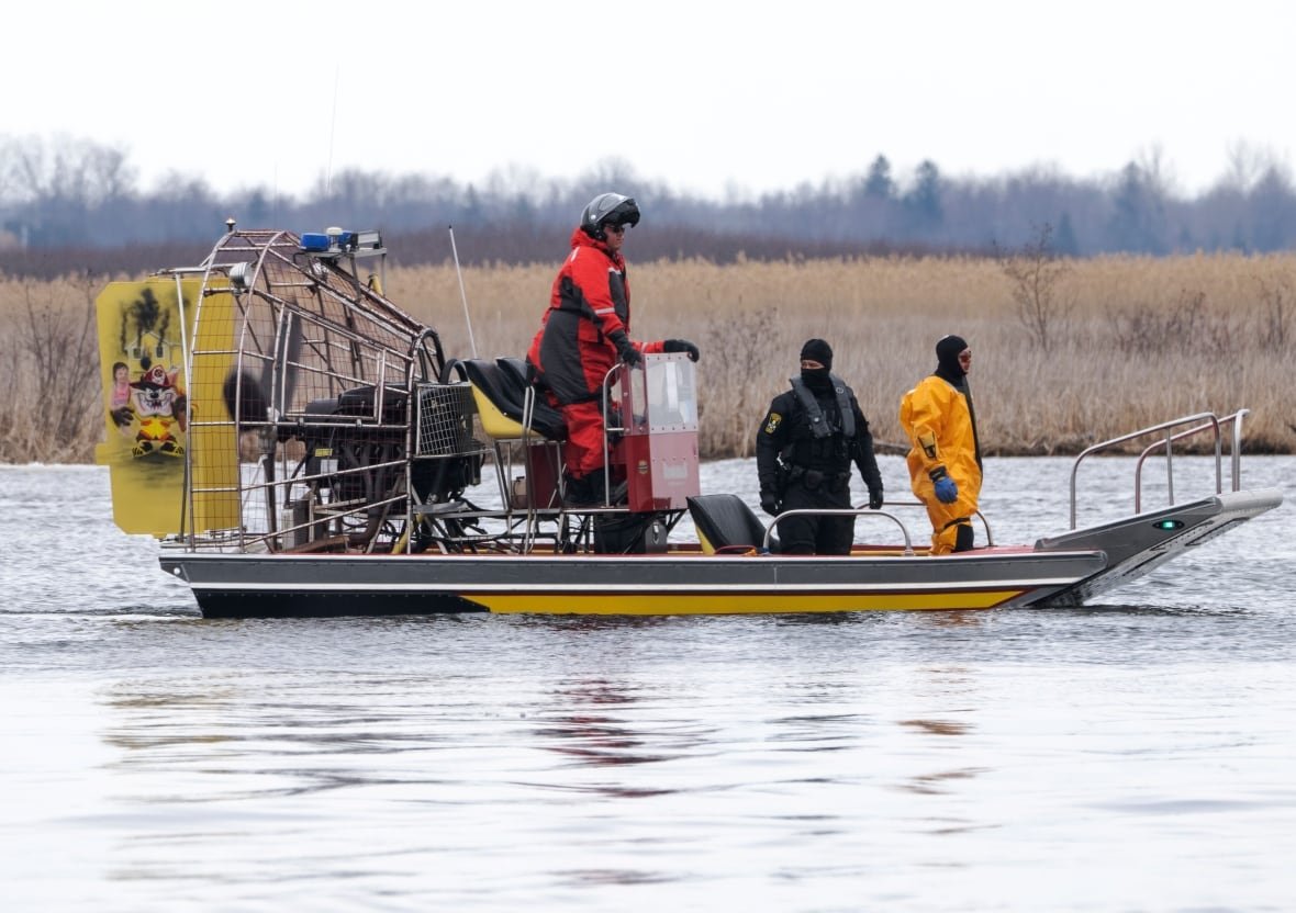 Searchers on a boat in the water.