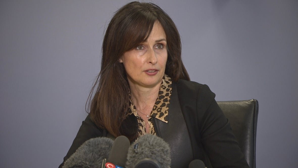 A woman seated in front of microphones. 