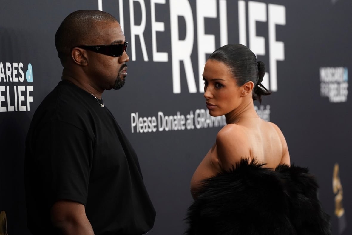 Two people wearing black pose