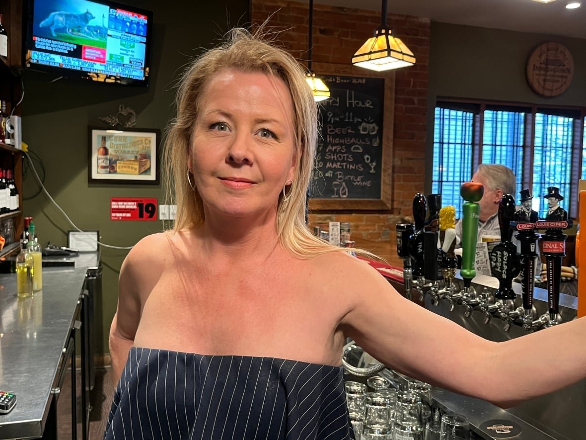 A woman is pictured behind a bar.