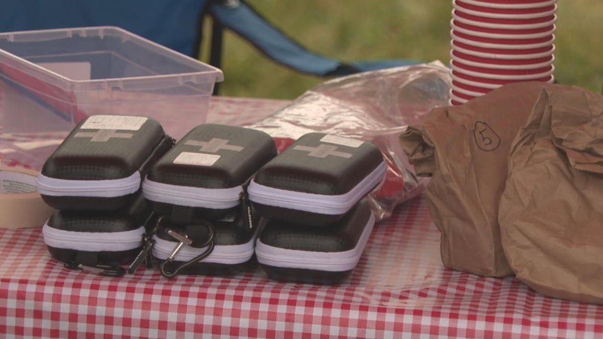 A table with cups and naloxone kits on it.