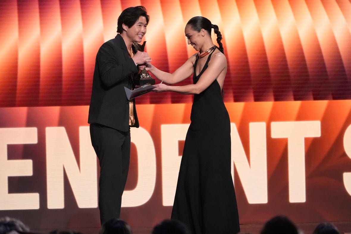 A person accepts an award from a presenter on stage.
