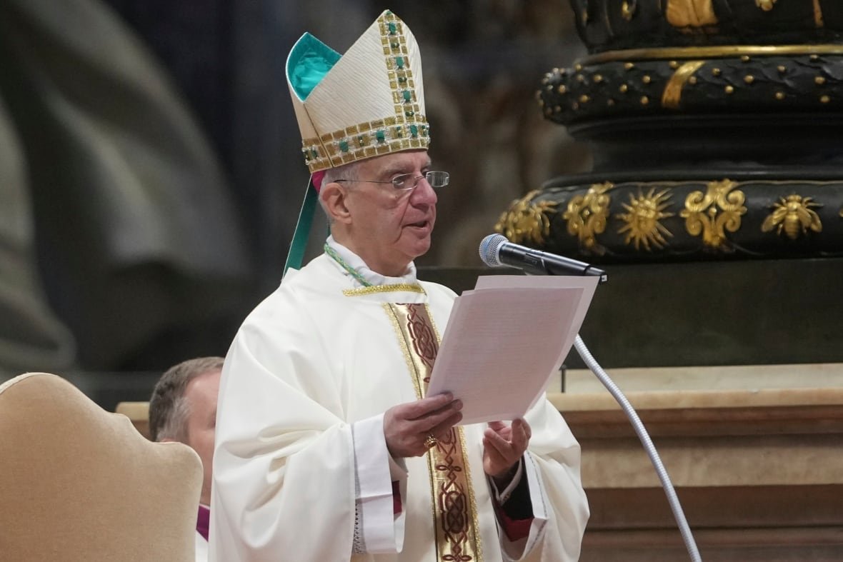 A person in religious garb reads off a piece of paper during a service.