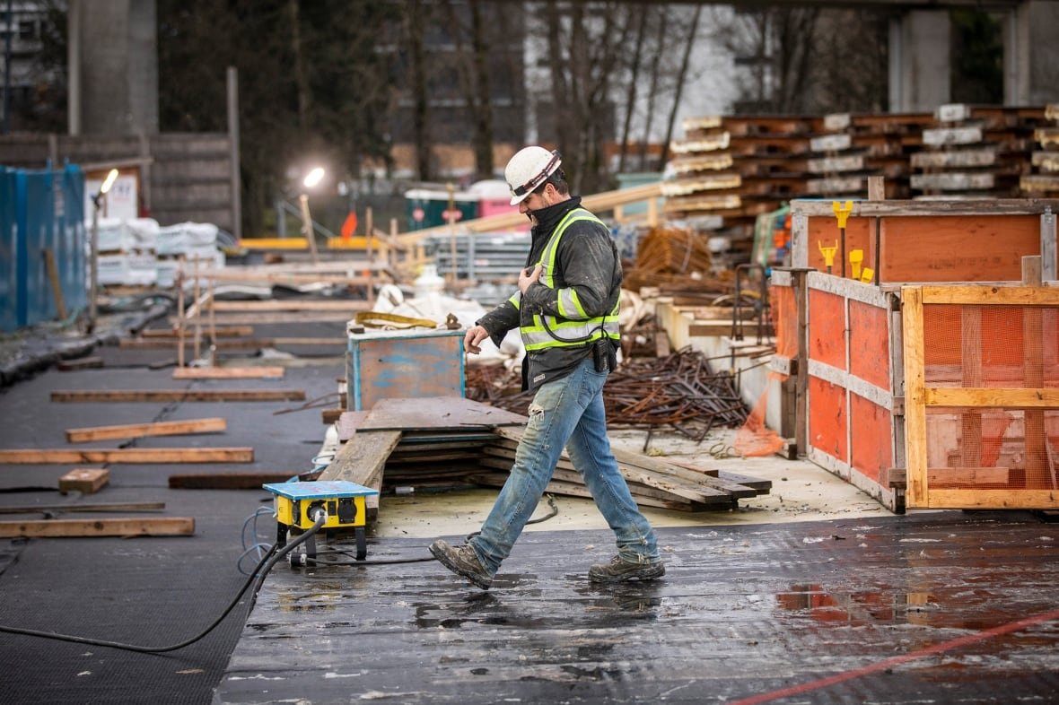 A construction worker walks on a site.