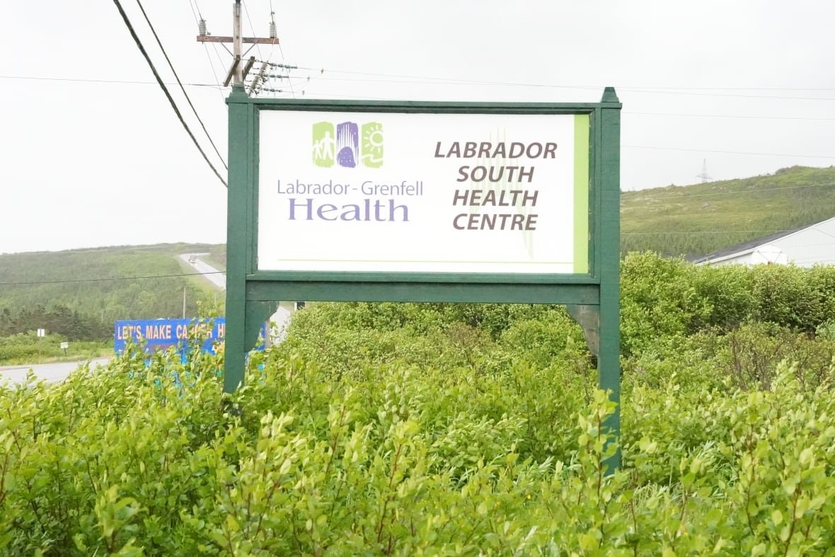 A white sign with a green wood frame says Labrador-Grenfell Health, Labrador South Health Centre. 