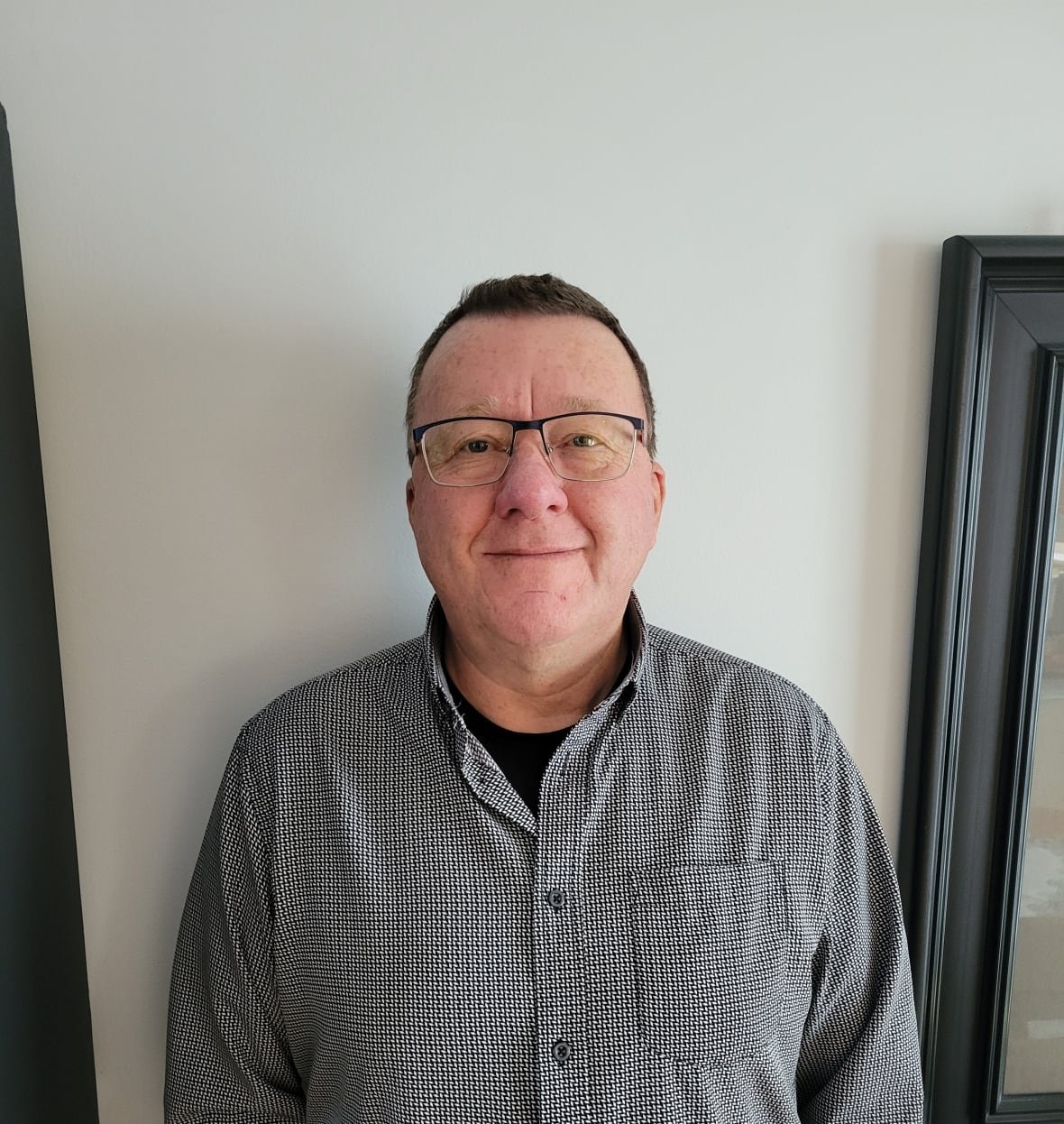 Man in grey sweater and wearing glasses