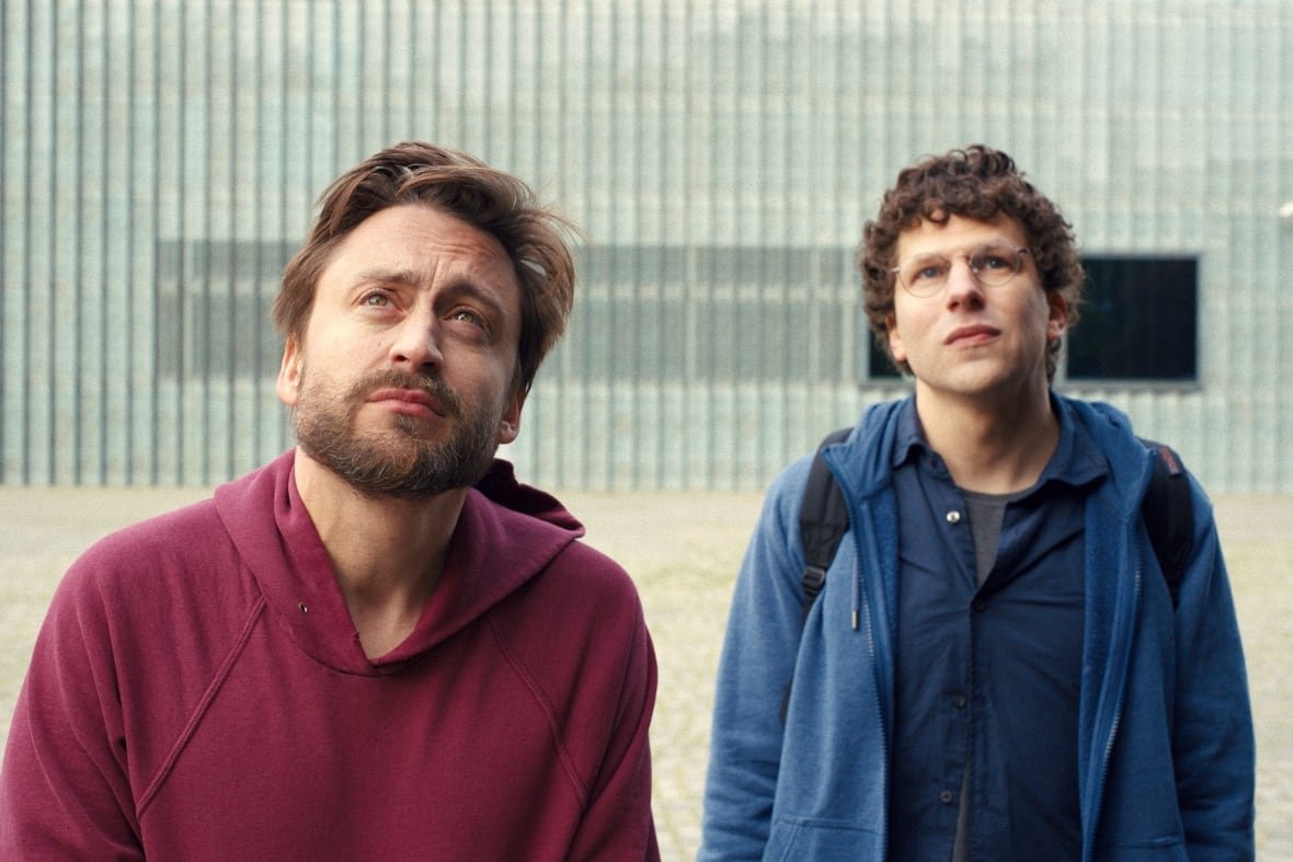 Two men look at something beyond the camera pointed at them.