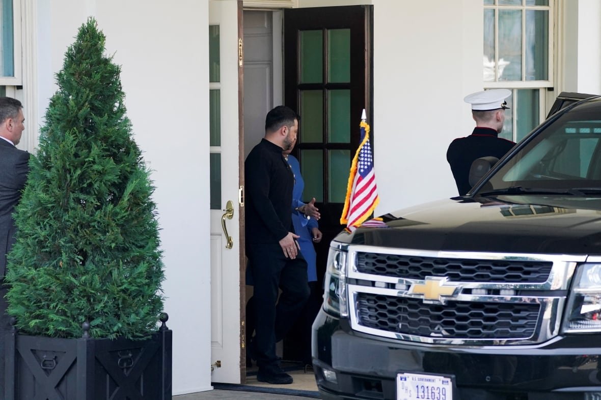 A man in formal black clothing leaves the White House and gets into a black SUV.