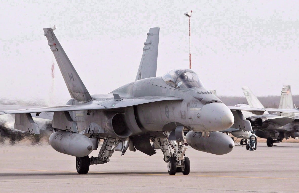 A fighter jet sits on the tarmac.