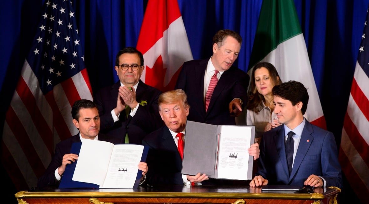 Trudeau, Pena Nieto and Trump hold up newly signed copies of the CUSMA pact in 2018