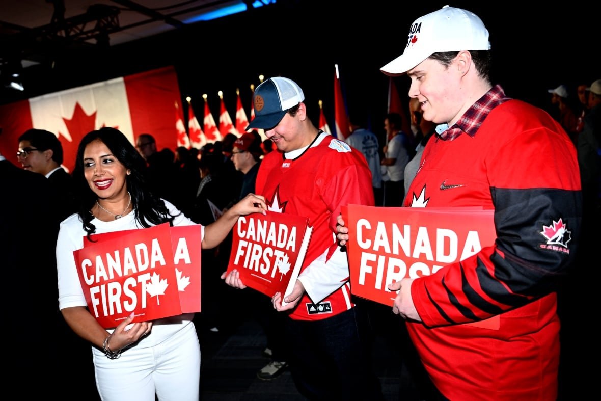 A supporter gets a sign before Conservative Leader Pierre Poilievre's Canada First rally in Ottawa, on Saturday, Feb. 15, 2025.