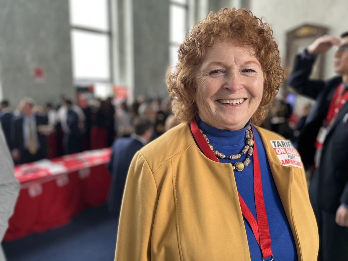 A woman with red, curly hair smiles for the camera.