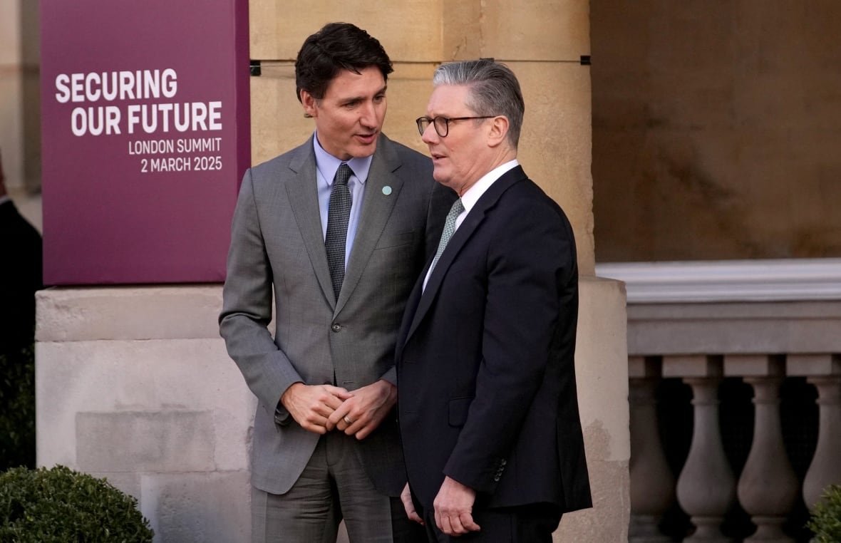 One man leans in while he talks with another man.