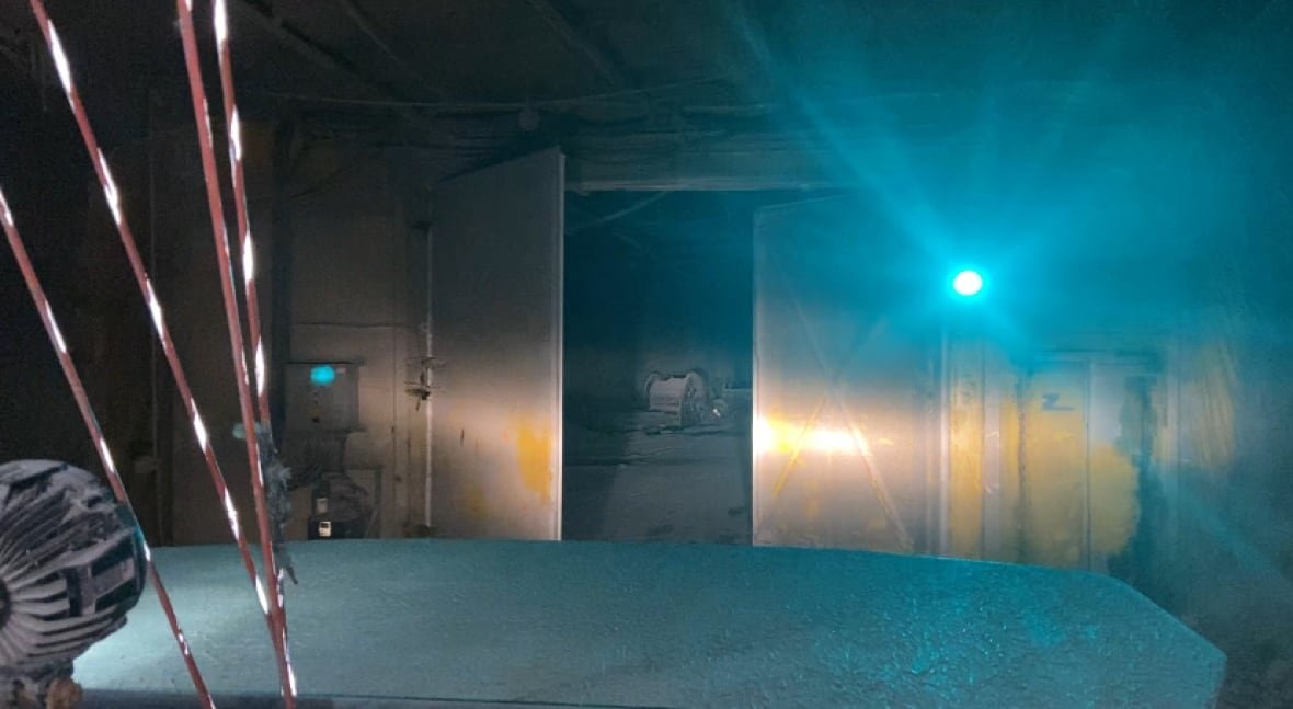 Image of a heavy door opening to allow the mining truck to drive through. The door protects the air pressure and the air ventilation system. 