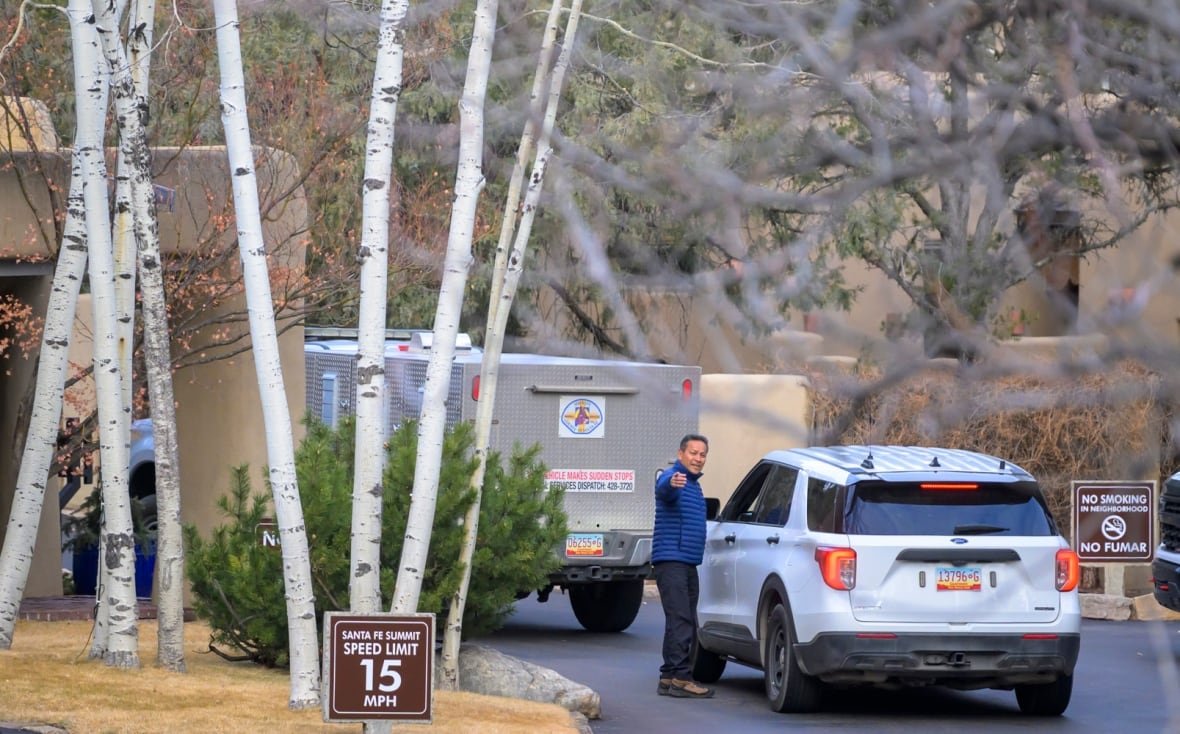 Police vehicles arrive at a mansion.