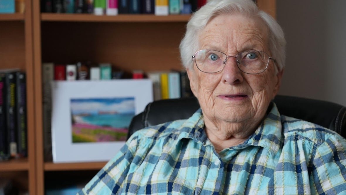 An older woman looks at the camera