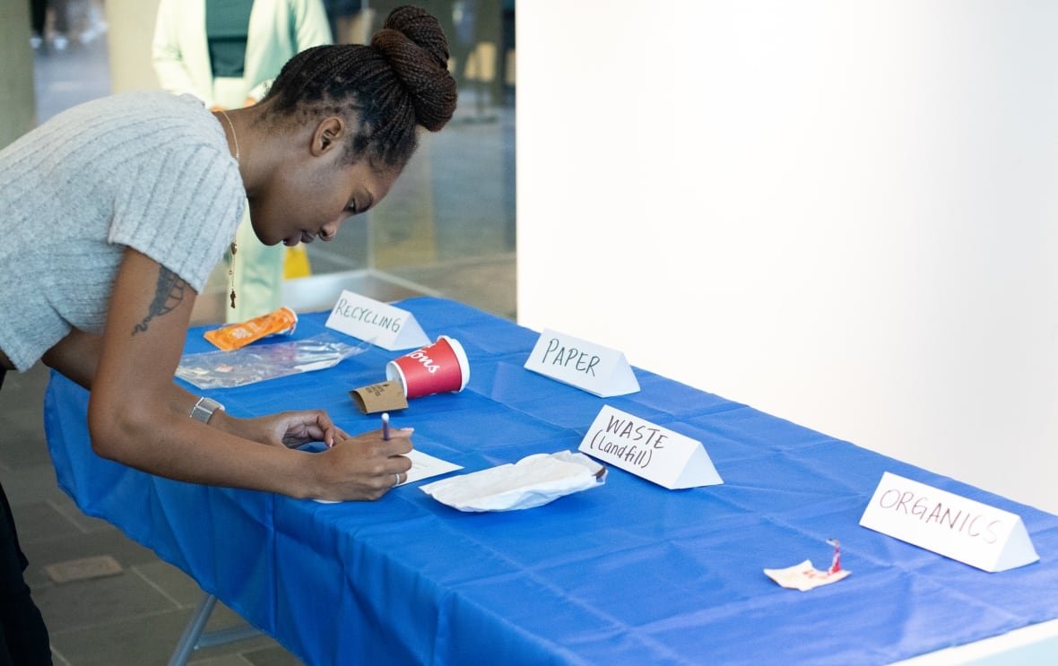 Leann Sealy-Hinds, a third-year kinesiology student, participates in the Ecoblitz event. Pieces of garbage are categorized and participants write down whether they think it’s correctly sorted or not. 