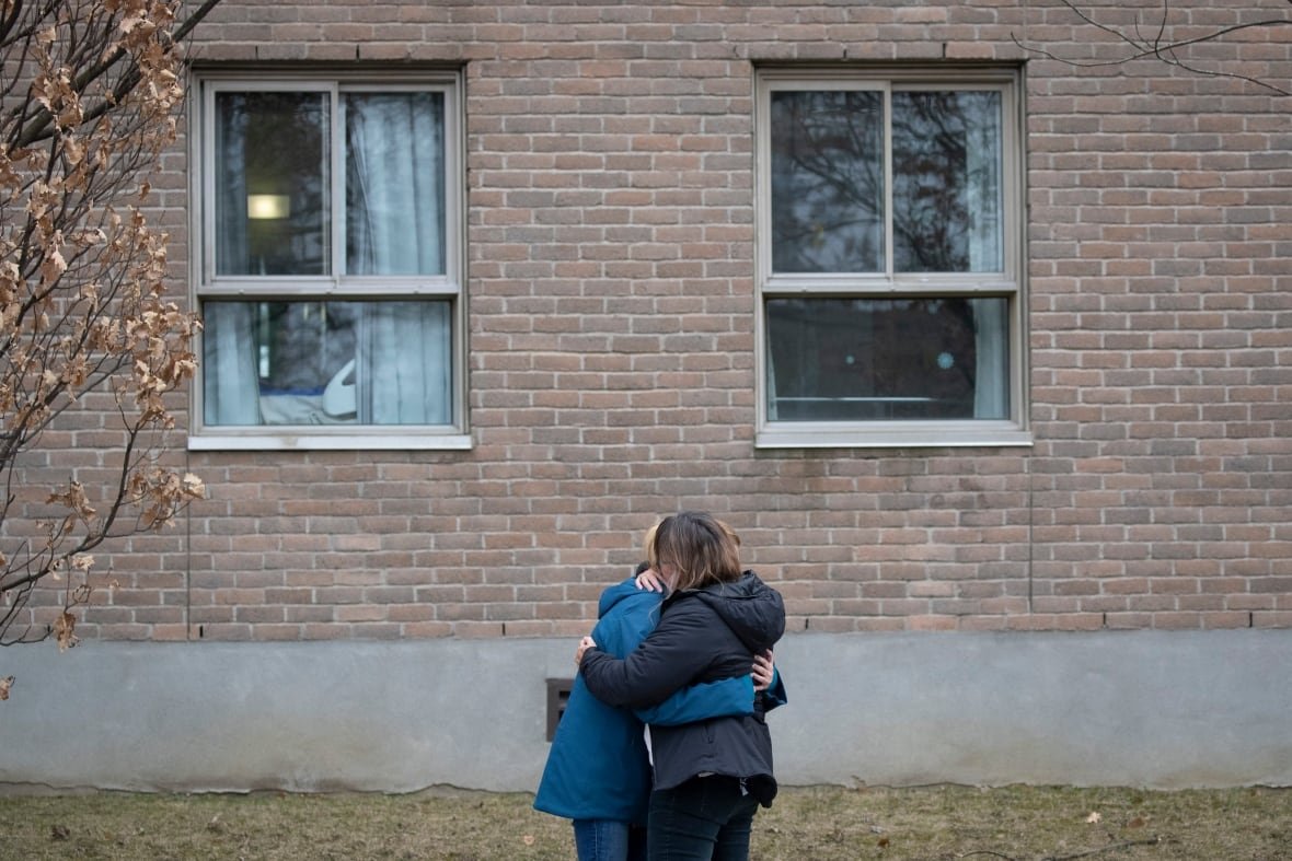 Two people embrace outside CHSLD Yvon-Brunet in the Sud-Ouest borough