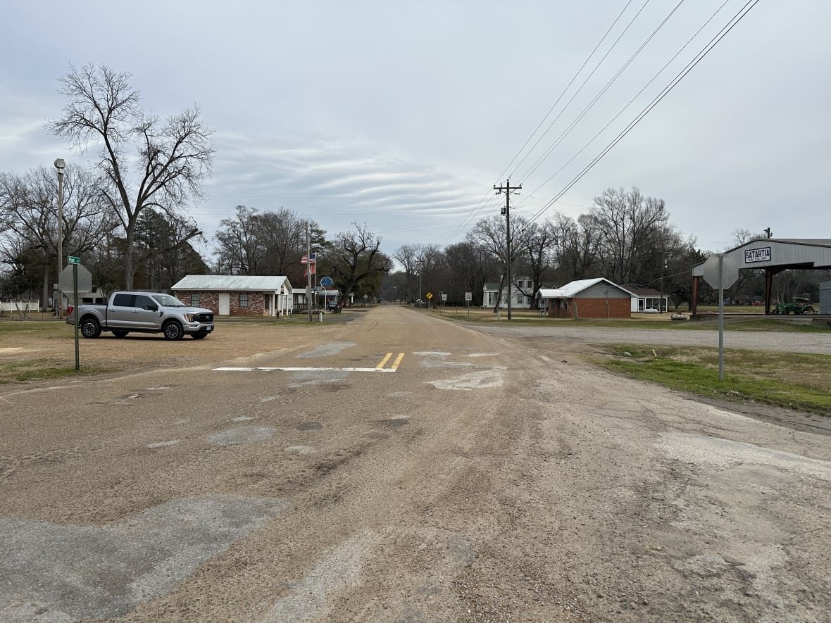 Shot of a wide country road running through a small American town.