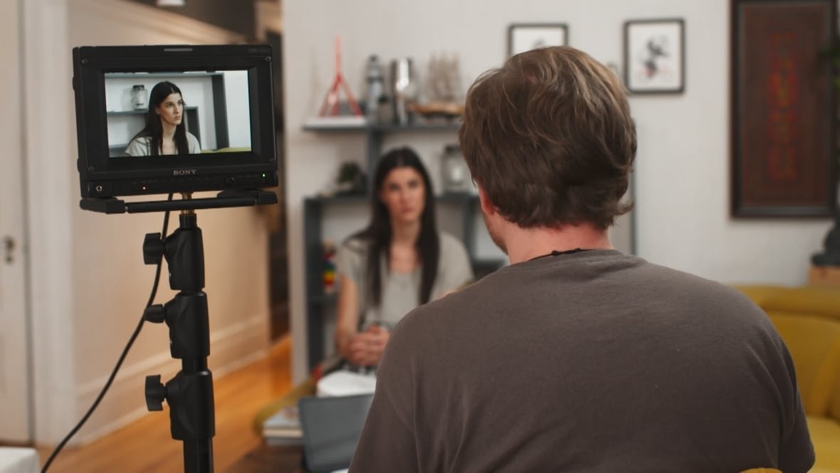 A person with their back to the camera speaks to another person.