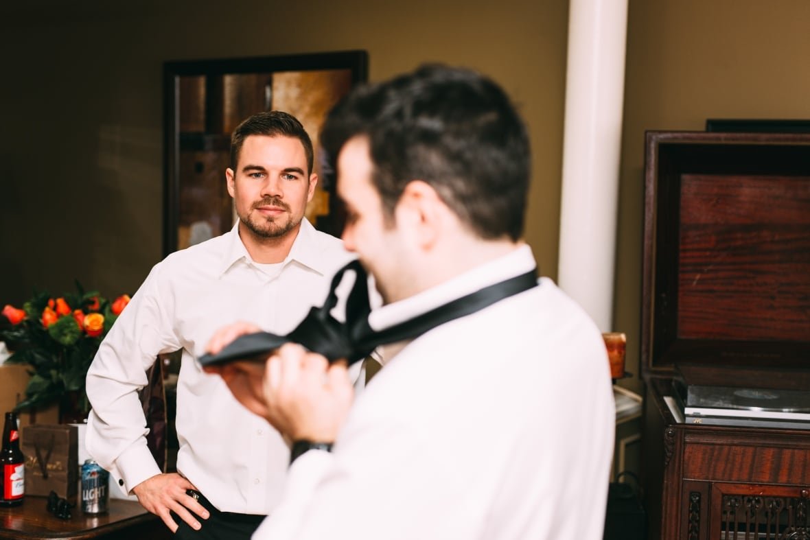 Two men stand in a room.