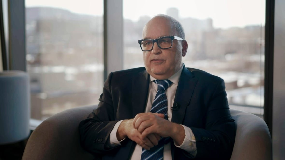 A person sits in a chair in front of a window.