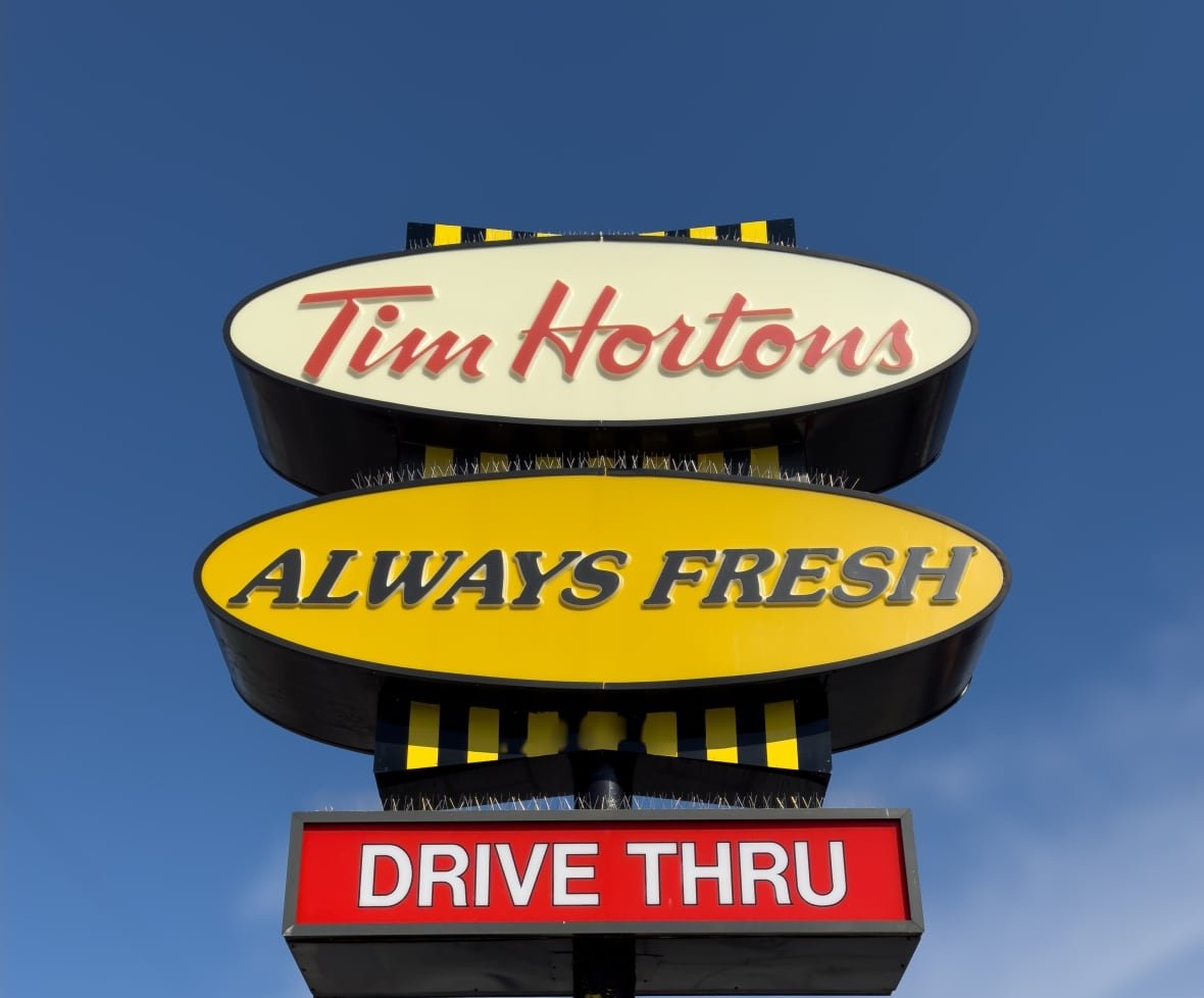 A Tim Hortons sign is seen with blue sky in the background. 