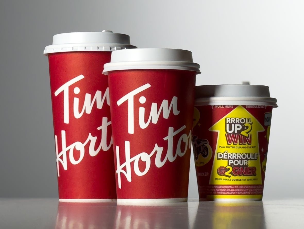 A studio shot shows three different sizes of Tim Hortons cups with lids on.