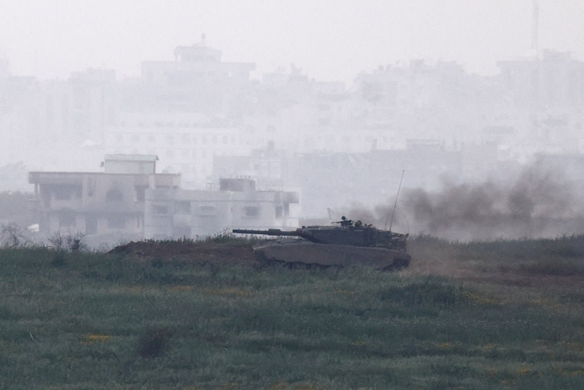 A tank drives through a green field