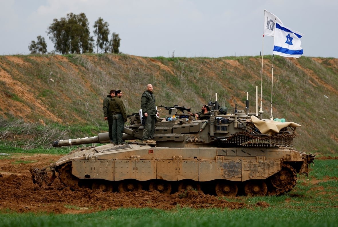 Soldiers stand on a tank