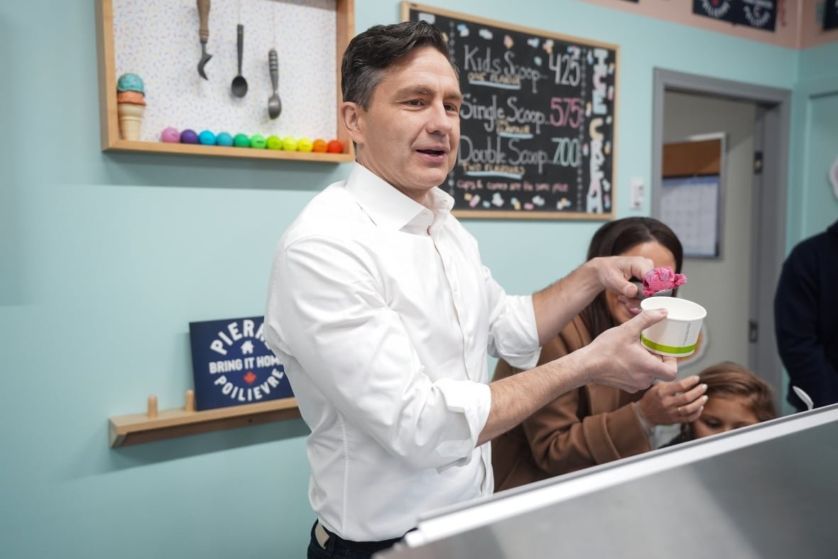 A man stands behind an ice cream counter.