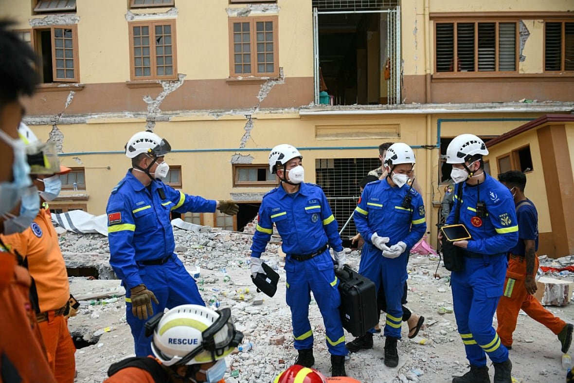 Members of an earthquake rescue team wear masks and helmets. 