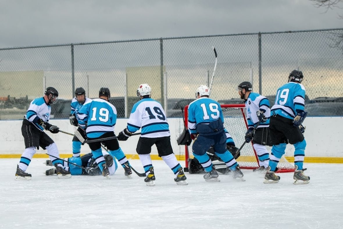 Hockey players skate on ice.